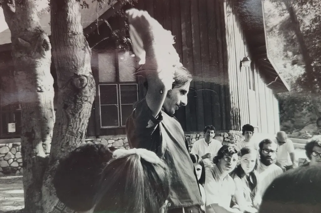 Tearing the tallit as in burning the draft card (protesting pseudo-Jewishness as assimilation to establishment USA)